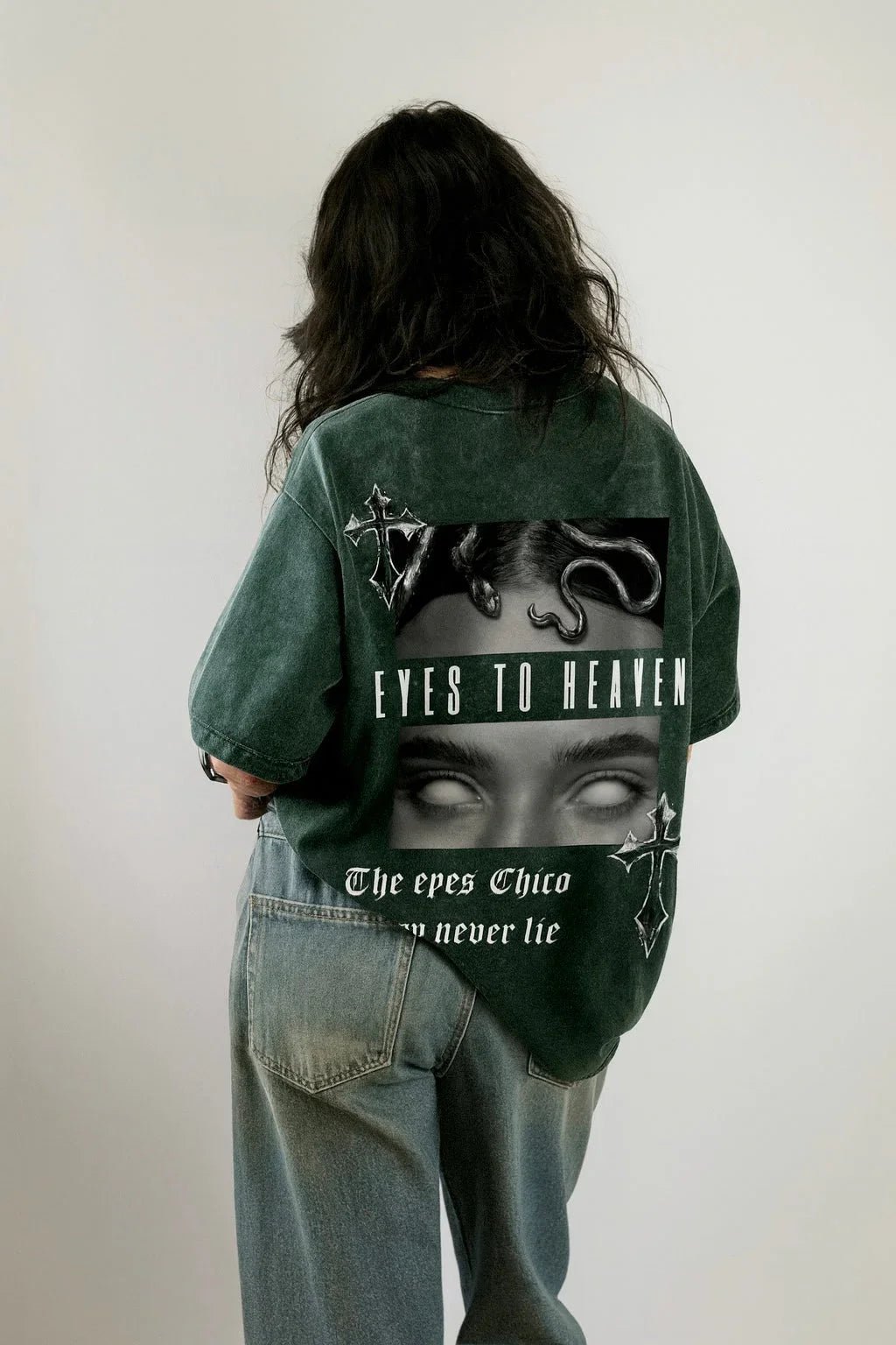 Back view of a model in acid wash oversized green tee with gothic 'Eyes to Heaven' graphic, Flex Your Vibe streetwear.