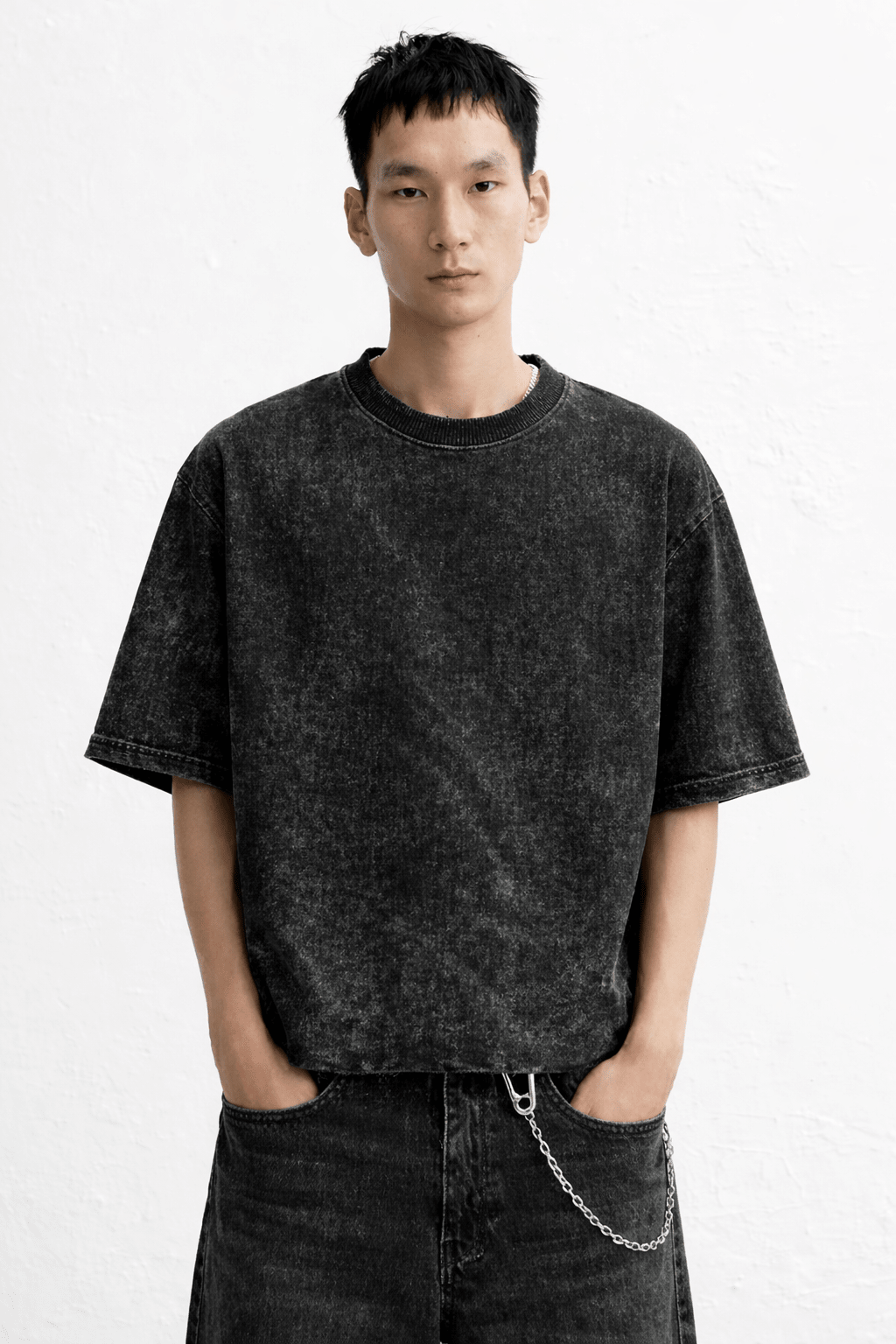 Person wearing a black t-shirt and jeans with a white background