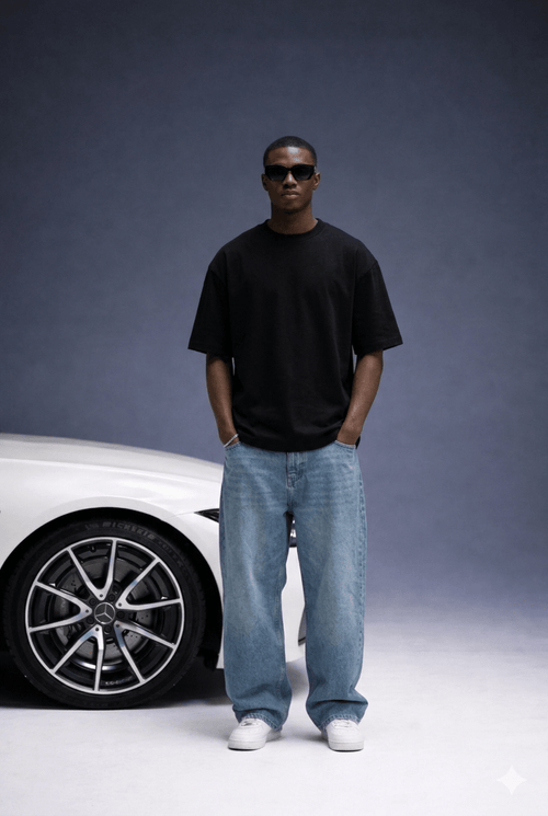 Man wearing a black t-shirt and sunglasses standing next to a white car on a gray background