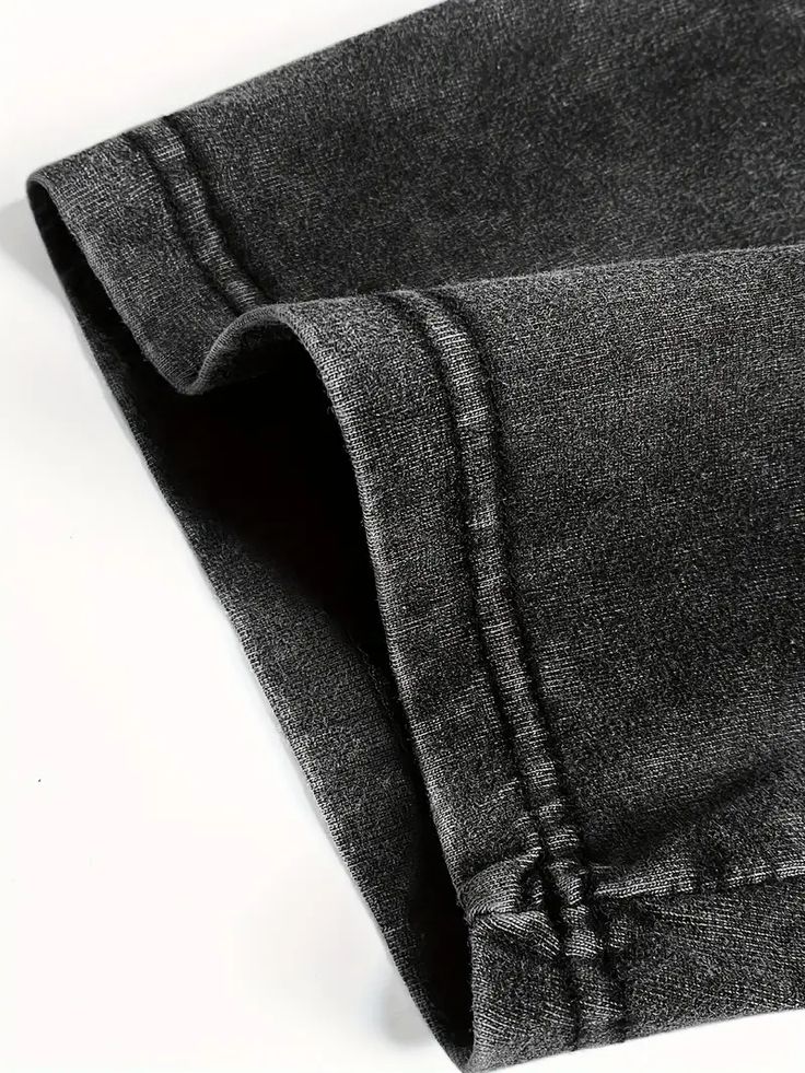 Close-up of black jeans on a white background